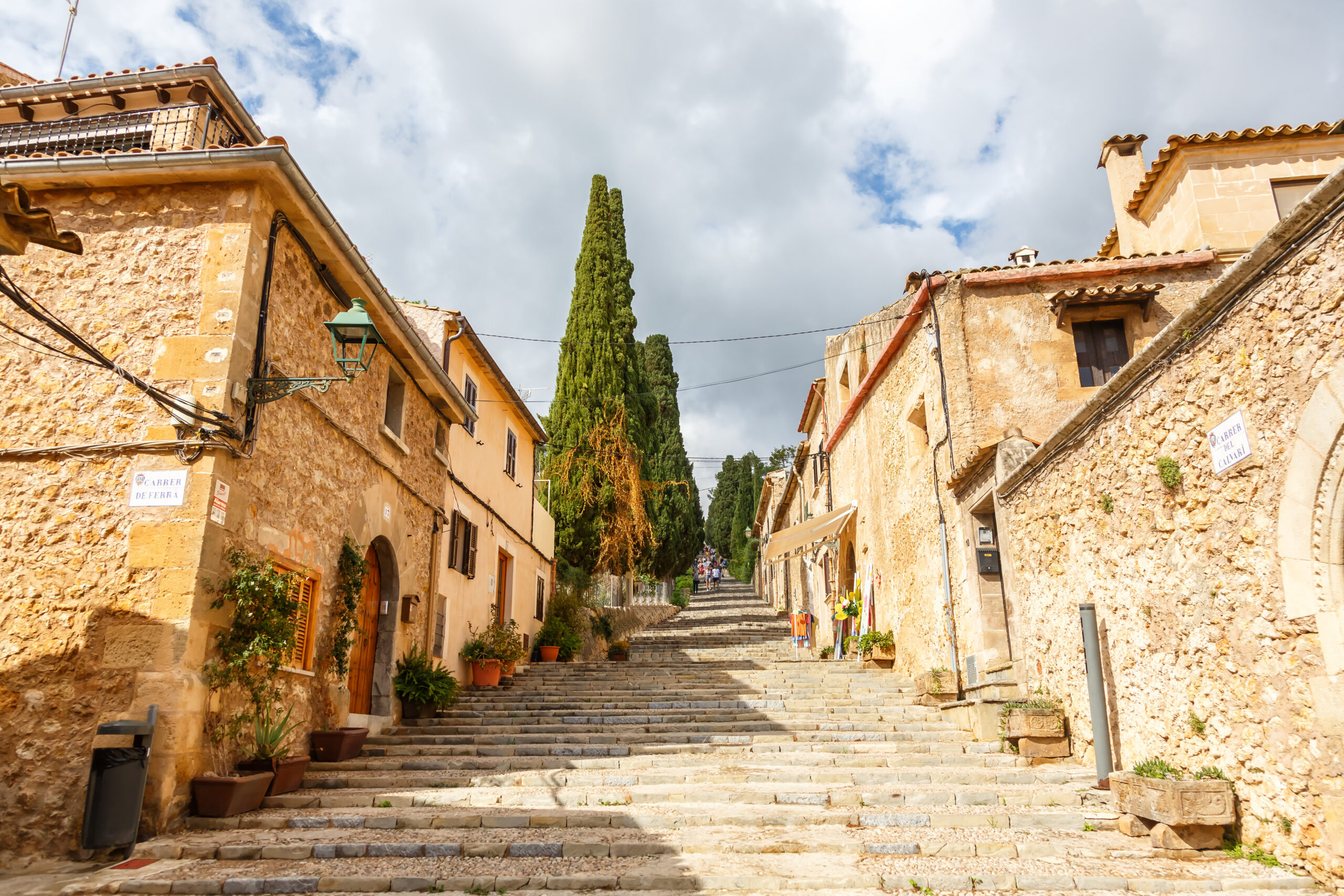 Kleines mallorquinisches Dorf mit Naturstein-Häusern, Bergen und mediterraner Landschaft.