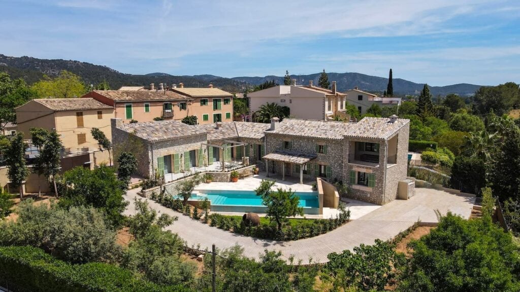 Finca-Anwesen aus Naturstein mit Pool, Innenhof und umliegender Berglandschaft.