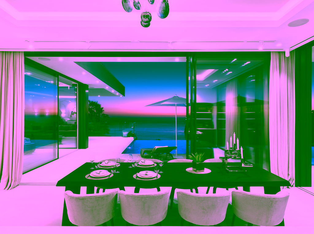 Eleganter Essbereich mit großem Tisch und modernen Stühlen; dahinter bodentiefe Glasfront mit Blick auf Infinity-Pool und Meer bei Sonnenuntergang.