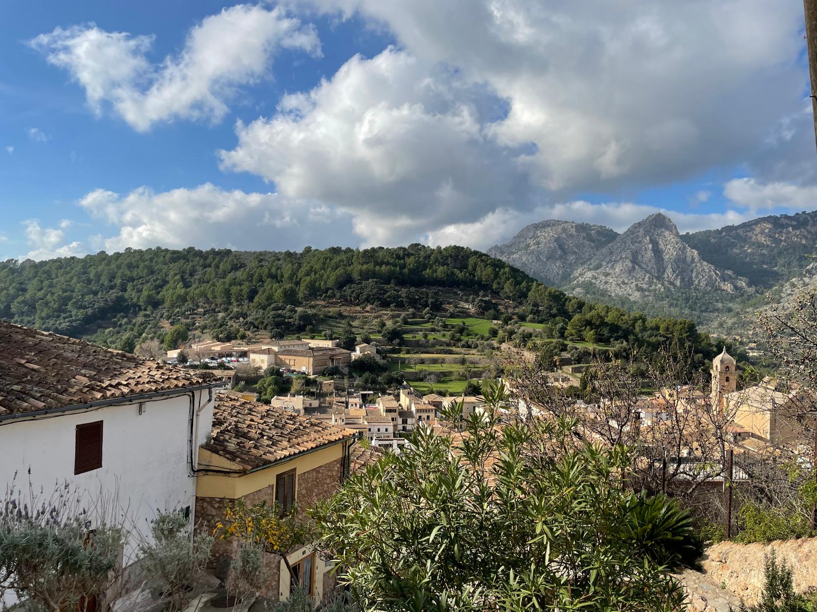 Blick auf ein mallorquinisches Dorf mit Kirche und Tramuntana-Bergen im Hintergrund